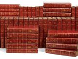 plusieurs livres rouges empilés les uns sur les autres sur une surface blanche
