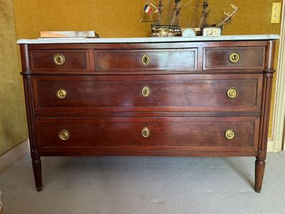 une commode en bois avec un plateau en marbre et des poignées en laiton
