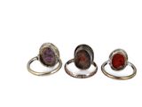 three rings with different colored stones on them sitting next to each other
