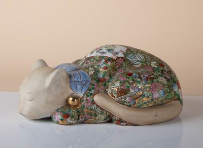 a figurine of a cat laying down on a table