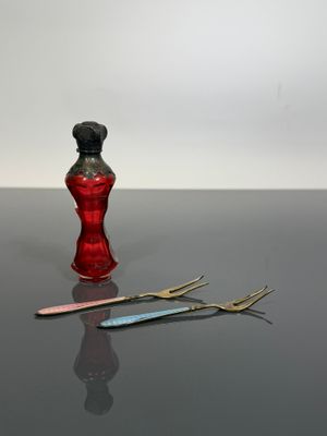 a red vase and a pair of scissors sitting on a table