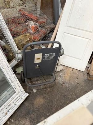un tas de vieilleries dans une cour, avec une porte et une fenêtre
