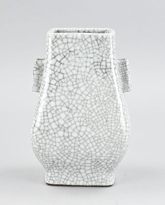 un gros plan sur un vase blanc dont la surface est craquelée