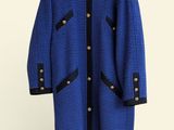 blue and black coat on a hanger against a white wall