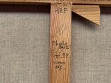 a wooden cross with writing on it on the wall