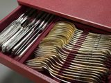 a red box with a bunch of silver spoons in it