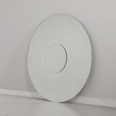 un miroir blanc rond accroché au mur dans un coin de la pièce