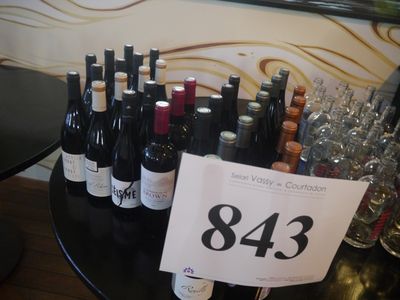 des bouteilles de vin posées sur une table, avec une étiquette de prix devant chacune d'elles