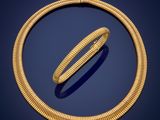 a gold necklace and bracelet set on a blue background