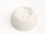 a white bowl with holes in it on a white surface