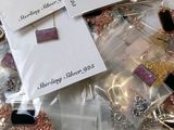 many different types of jewelry in bags on the table