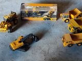 trois engins de chantier miniatures posés par terre