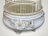 a white bird cage with a bird inside of it