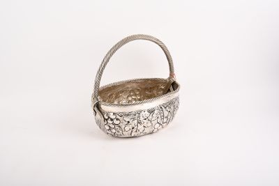 panier plaqué argent orné de fleurs sur un fond blanc