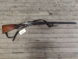 the rifle is laying on the floor next to the wooden floor