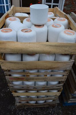 de nombreux rouleaux de papier toilette dans un panier posé sur une palette