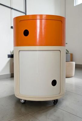 une armoire orange et blanche sur roulettes dans une pièce