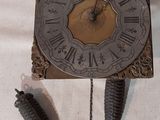une horloge posée sur une table, avec une plume