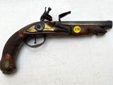 un vieux pistolet posé sur une surface blanche