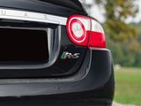 the rear end of a black sports car parked on the side of the road