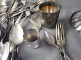 many silver spoons and forks on the table