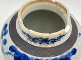 a blue and white vase with a brown rim