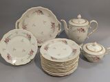 plusieurs assiettes et tasses et une théière sur la table