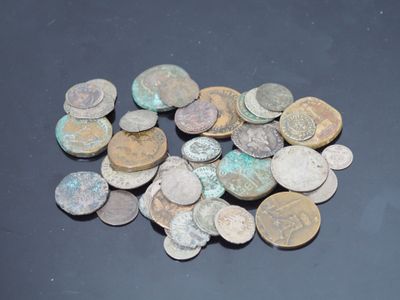 quelques vieilles pièces de monnaie sont posées sur une table au plateau noir