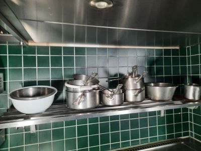 de nombreuses casseroles et poêles sur l'étagère de la cuisine