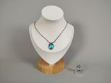 Ensemble collier et boucles d'oreilles présenté sur un présentoir en bois, sur fond gris