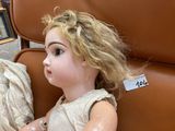 a little girl sitting on a chair with a teddy bear