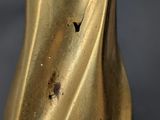 a close up of a gold vase on a table