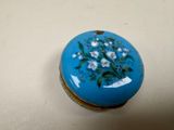 a small blue box with flowers painted on it