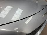 a close up of a car ' s hood with a window in the background