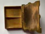 an old brass box with a small open lid on a white surface
