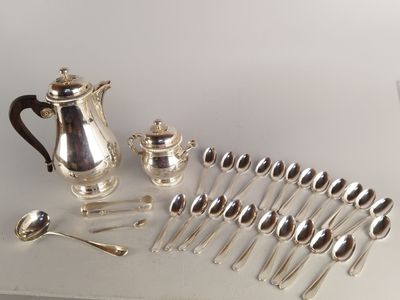 a lot of silver spoons and a silver teapot on a table
