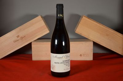 a bottle of wine sitting on a table next to two wooden boxes