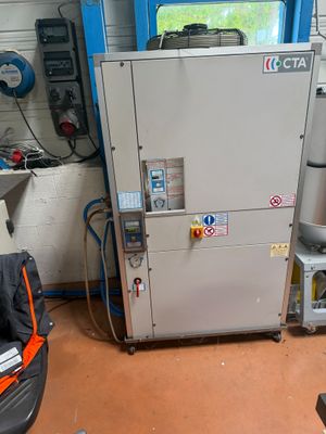 une photo montrant une machine dans un garage, avec un bébé dans une poussette