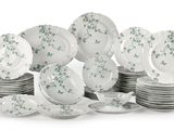 a pile of plates and bowls with green flowers on them