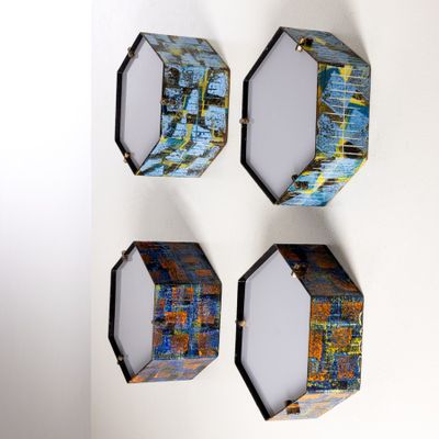 Trois œuvres d'art sont accrochées au mur d'une pièce