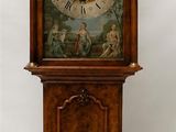 une horloge de parquet en bois surmontée d'anges