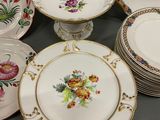 many plates and cups on the table with flowers on them
