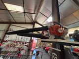 une photo d'une tronçonneuse dans un garage, à côté d'autres outils