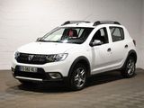 La Dacia blanche est garée dans une pièce blanche au sol carrelé