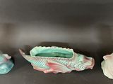 three ceramic fish shaped vases sitting next to each other on a table
