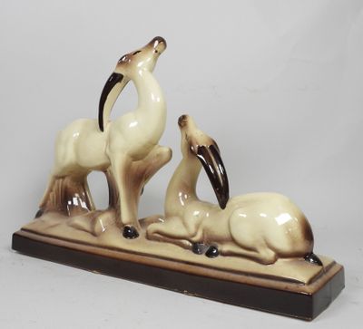 a figurine of a goat and a goat laying down