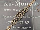 un bracelet en chaîne d'or orné de diamants posé sur une carte de visite