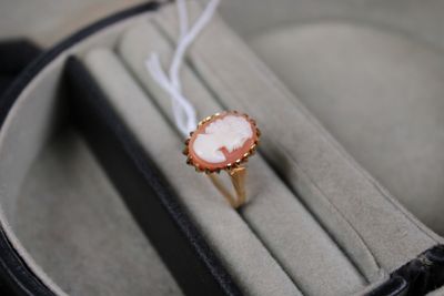 une bague sur laquelle est gravée l'image d'une femme, présentée dans un écrin