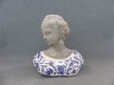 une statue représentant une femme vêtue d'une robe bleue et blanche