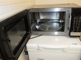 two microwaves sitting on top of each other in the kitchen